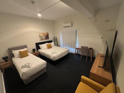 a room with two beds and a table and a couch at Riverwood Hotel - Adults Only in Riverwood