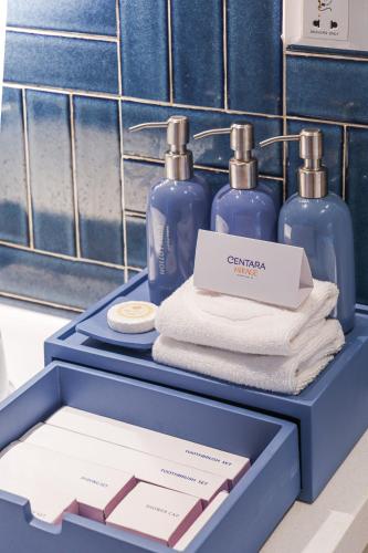 a blue box with two bottles of soap and towels at Centara Mirage Resort Mui Ne in Mui Ne
