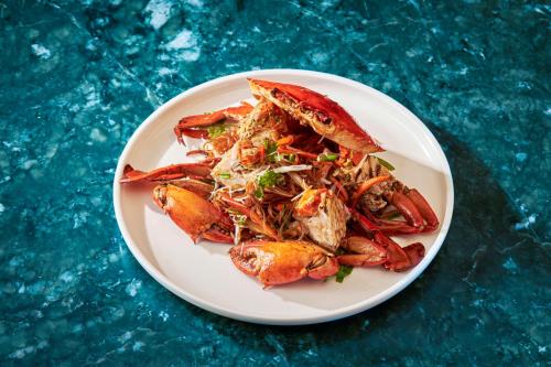 a plate of food with crabs on a blue table at Centara Mirage Resort Mui Ne in Mui Ne