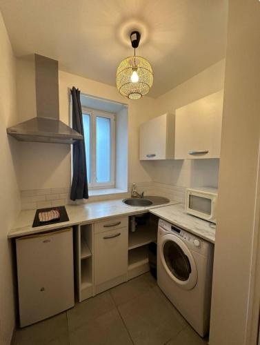 une cuisine avec un évier et une machine à laver dans l'établissement Studio zen, à Saint-Brieuc