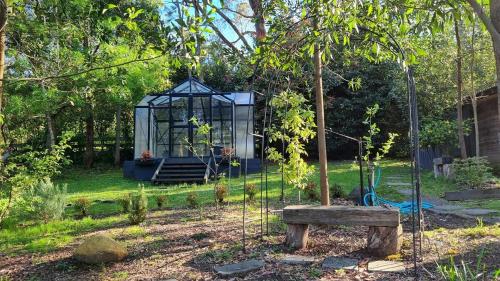 a playground in a garden with a gazebo at Camellia Grove Retreat in Mount Macedon