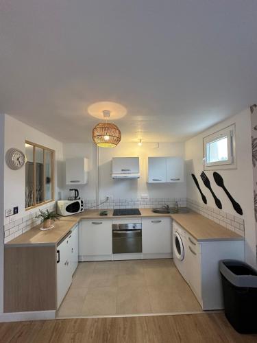 La cuisine est équipée de placards blancs et d'un lave-vaisselle. dans l'établissement Pause Déco, à Saint-Brieuc