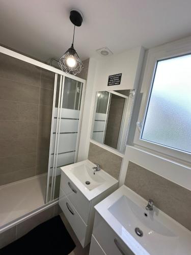 La salle de bains est pourvue de 2 lavabos, d'une douche et d'un miroir. dans l'établissement Pause Déco, à Saint-Brieuc