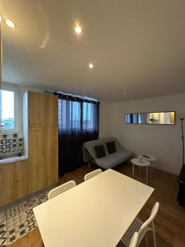 a living room with a table and chairs and a couch at Mon toit douillet in Saint-Brieuc