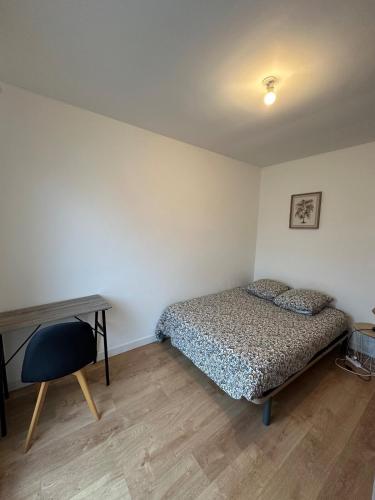 une chambre avec un lit, un bureau et une chaise dans l'établissement Mon toit douillet, à Saint-Brieuc
