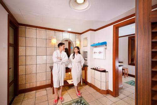 a man and a woman standing in a bathroom at Grand Lexis Port Dickson in Port Dickson