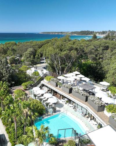 Una vista aérea de un complejo turístico con piscina y sombrillas. en Bannisters Pavilion Mollymook, en Mollymook