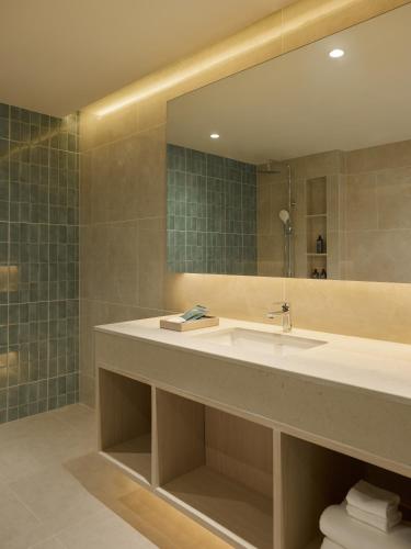 a bathroom with a sink and a large mirror at Marni Pattaya in Pattaya South