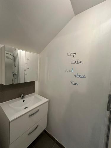 une salle de bain avec un lavabo et un miroir au mur dans l'établissement Sous les toits, à Saint-Brieuc