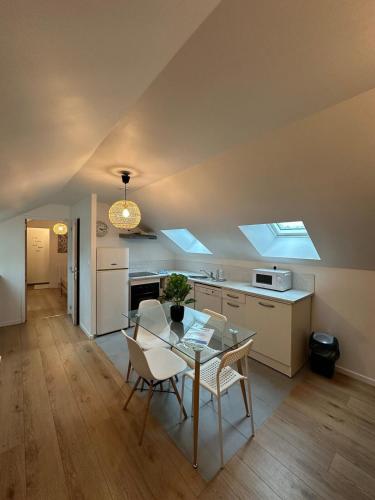 une cuisine et une salle à manger avec une table et des chaises dans l'établissement Sous les toits, à Saint-Brieuc