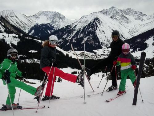 a group of three people standing on a ski slope at Gästehaus Bergland in Berwang