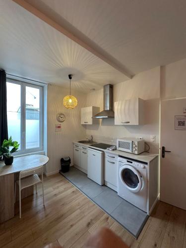 une cuisine avec une machine à laver et une table dans l'établissement Coin cosy, à Saint-Brieuc