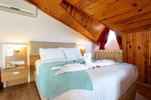 Un dormitorio con una cama con un cisne encima. en Turkuaz Hotel, en Büyükçekmece
