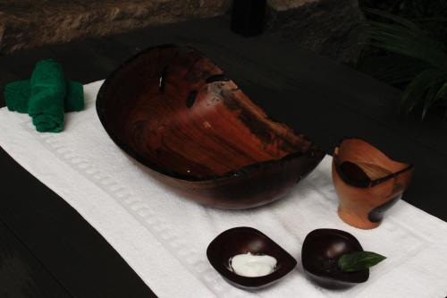 a wooden bowl and two black bowls on a table at Secret Bungalows Lechu in Chachagua