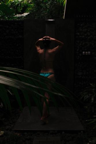 a woman in a blue bathing suit taking a picture in a mirror at Secret Bungalows Lechu in Chachagua