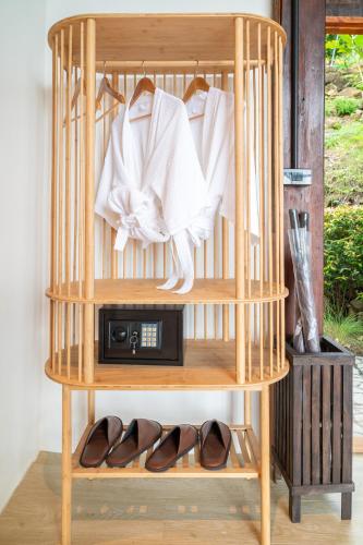 a wooden shelf with shoes and a radio in a room at RoomQuest THEVA Resort Koh Samui in Koh Samui 