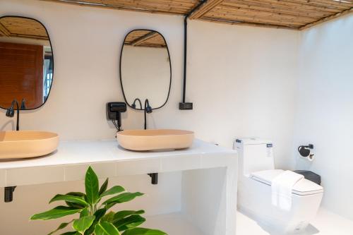 a bathroom with two mirrors and a toilet at RoomQuest THEVA Resort Koh Samui in Koh Samui 