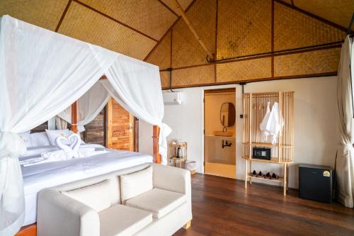 a bedroom with a white bed and a white couch at RoomQuest THEVA Resort Koh Samui in Koh Samui 