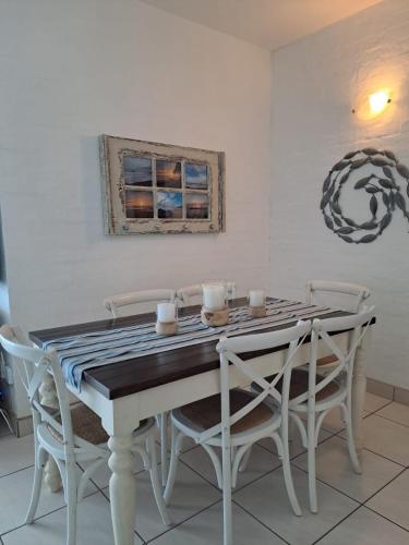 a dining room with a table and chairs at Easy Breezy at 18 Thira Santorini in Ballito