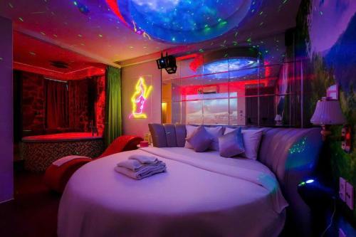 a bedroom with a bed with purple and pink lights at KS Tình Nhân Sach Hotel in Ho Chi Minh City