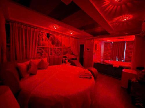 a red bedroom with a large bed with red lighting at KS Tình Nhân Sach Hotel in Ho Chi Minh City