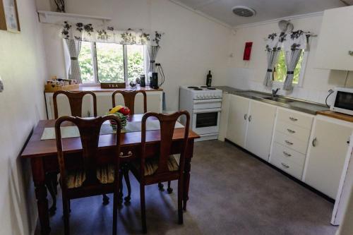 eine Küche mit Tisch und Stühlen und einem Herd in der Unterkunft Kooringa Cottage in Burra