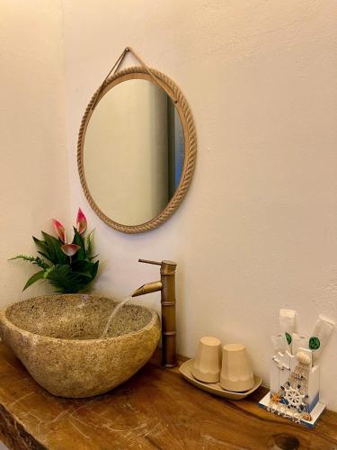 a bathroom with a stone sink and a mirror at Homestay Văn Vĩnh Hy 3 in Ninh Hải