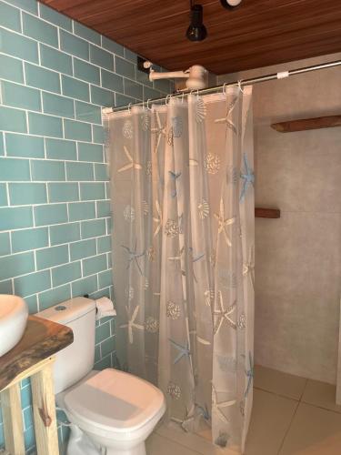 a bathroom with a toilet and a shower curtain at Apt Maracaipe, Porto de Galinhas in Porto De Galinhas