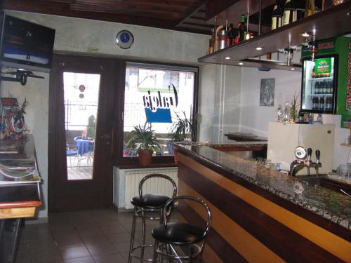 a bar in a restaurant with two stools at Guest House Rože in Ilirska Bistrica