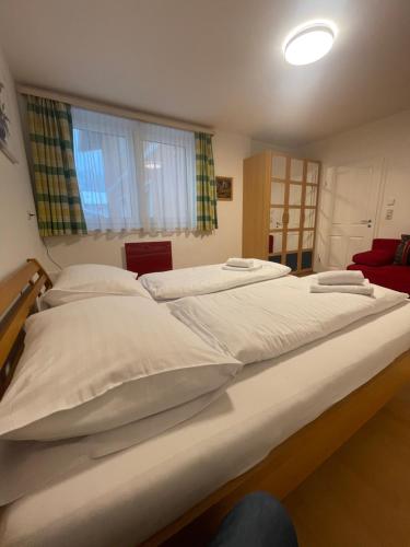 duże łóżko z białą pościelą w sypialni w obiekcie Appartement Berger w mieście Zell am See