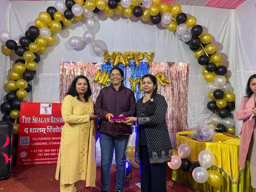 a group of people standing in front of a arch with balloons at The Shalam Resort श्रीकृष्ण शरणं मम in Lansdowne