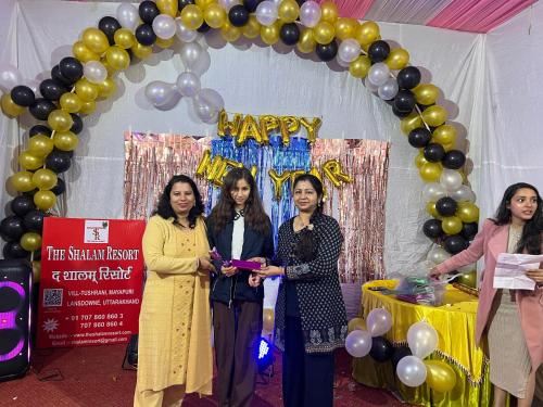 three women standing in front of a arch with balloons at The Shalam Resort श्रीकृष्ण शरणं मम in Lansdowne