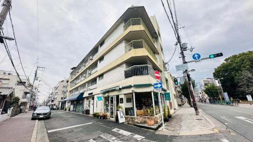 a building on the side of a street with a car at Nagai park side stay premium in Osaka