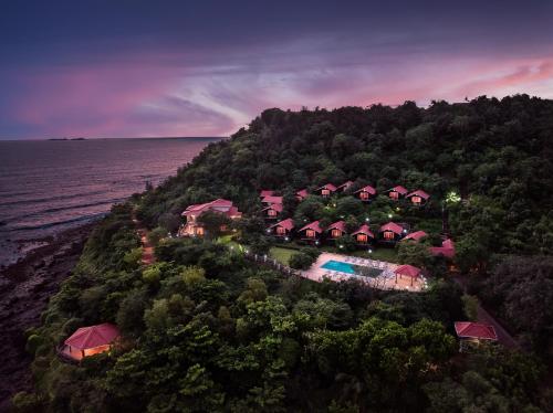 an aerial view of a resort on a hill next to the ocean at Highland Sarovar Portico Sindhudurg in Bhogwe