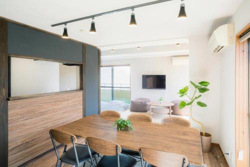 a dining room with a wooden table and chairs at A&m花畑501 in Kumamoto
