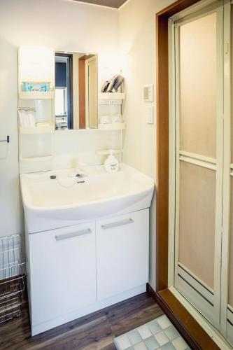 a bathroom with a white sink and a mirror at A&m花畑501 in Kumamoto