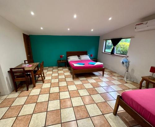 a room with a bed and a table and a room with green walls at Hospedaje Soma in Moyogalpa
