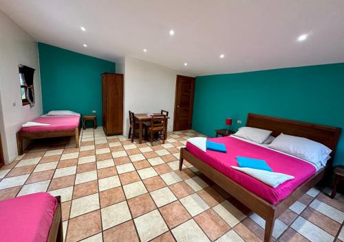 a bedroom with two beds and a green wall at Hospedaje Soma in Moyogalpa