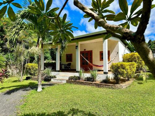 a house with a red door and some palm trees at Hospedaje Soma in Moyogalpa