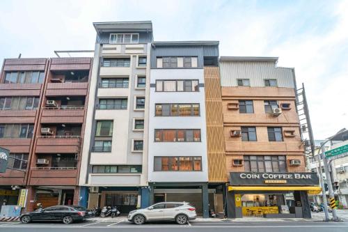 a tall building with cars parked in front of it at Tsum chill in Tainan