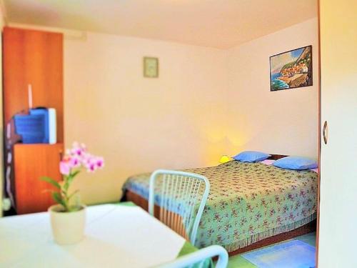 a small bedroom with a bed and a table at Apartment Koric in Ičići