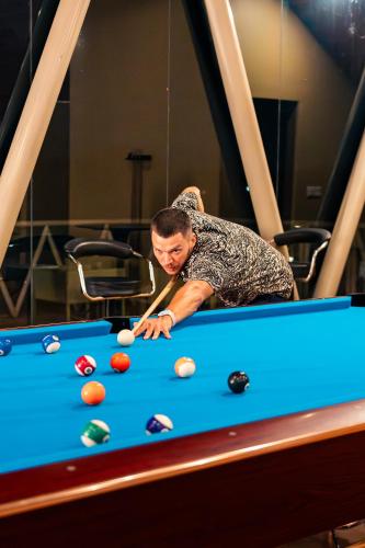 a man playing a game of pool on a pool table at Bolagala Agro Floating Resort in Negombo