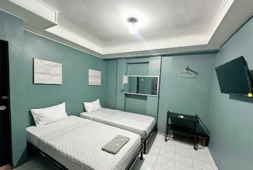 two beds in a room with blue walls at Ghaza Guest House in Padang