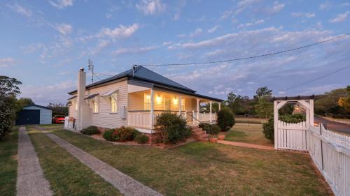 a small white house with a white fence at Creekview Cottage - 70 Lock Street in Stanthorpe