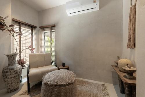 un soggiorno con sedia e vaso di Private Pool, 8-Bedroom, Old Town, Entire Estate - TANPURI Thapea - Prime Location a Chiang Mai