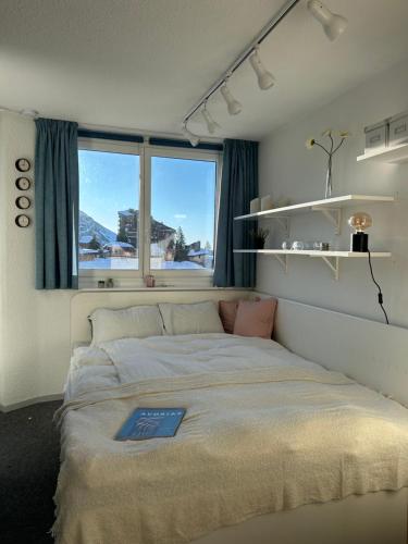 a bedroom with a large bed with a window at Hygge Ski-in-Ski-out med udsigt in Avoriaz