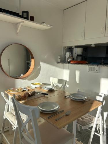 - une cuisine avec une table en bois, des chaises et un miroir dans l'établissement Hygge Ski-in-Ski-out med udsigt, à Avoriaz