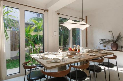 a dining room table with chairs and a large window at Private Pool, 8-Bedroom, Old Town, Entire Estate - TANPURI Thapea - Prime Location in Chiang Mai