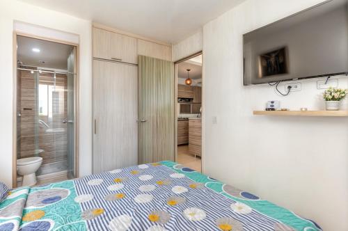 a bedroom with a bed and a bathroom at Loft en Nrt de Barranquilla - Piscina - Mall 3 Min in Barranquilla