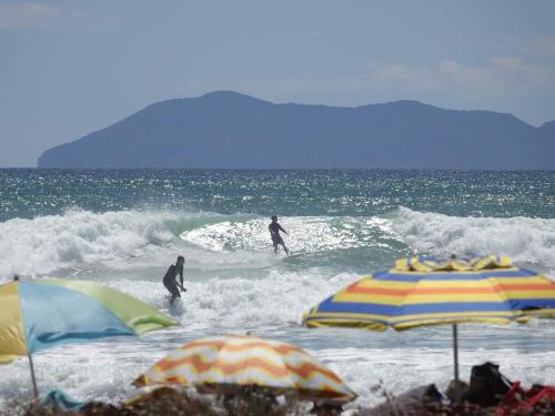 two people surfing on the waves in the ocean at Peace Of Bali in Waihi Beach